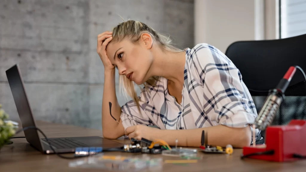 a young women sitting on a chair working on laptop 