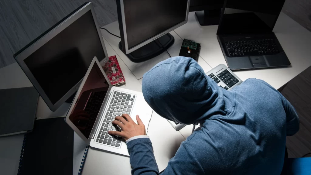 a cloud security professional working on 3 laptops